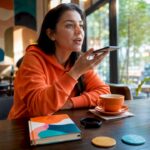 Woman using AI assistant via smartphone voice command
